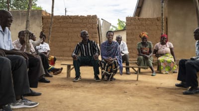 Rwandier sitter tillsammans i en försoningsby. 