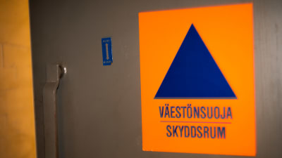 Bombsäker dörr med klistermärke som visar att innanför finns ett skyddsrum.