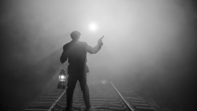 Pojke står med en stormlykta och en pistol och stannar ett annalkande tåg. Iscensatt bild för dokumentären.