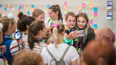 Amanda Edmundsson hälsar på sina fans. Flera unga kvinnor flockar runt Edmundsson. Edmundsson tar som bäst en selfie med ett fan.