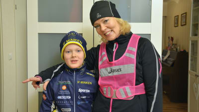Katarina Liljeqvist och hennes son står klädda i träningskläder i hallen