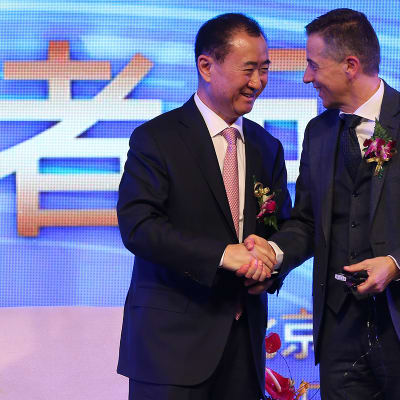 Wang Jianlin vasemmalla kättelee  Philippe Blatteria.
