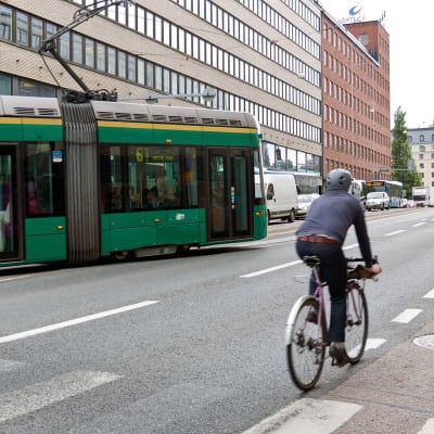 Bilden visar en väg med en cyklist och en spårvagn.