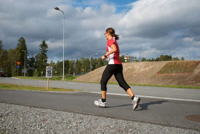 Kvinna springer på landsväg.
