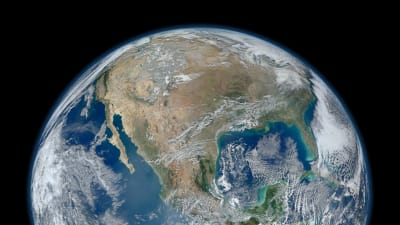 Jorden sedd från rymden. På jorden syns den västra halvklotet med hav omrking samt molk.