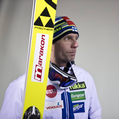 Janne Ahonen med skidorna i handen.