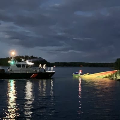 Sjöbevakningens båt belyser en motorbåt som delvis sjunkit på Erstan.