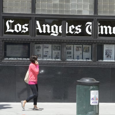 Ikkunoissa lukee teksti Los Angeles Times, lisäksi ikkunoissa sanomalehtiä. 