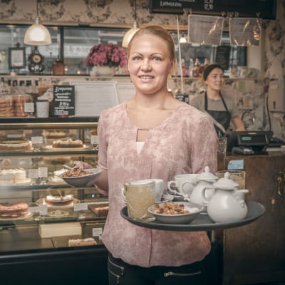 Miriam Laitinen tarjotin kädessään valmiina viemään tilaukset pöytään.