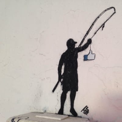 "Fishing for likes". En miniatyrmålning ovanför ett elskåp.
