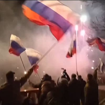 Venäjän lippuja heiluttavia ihmisiä kadulla Donetskissa.