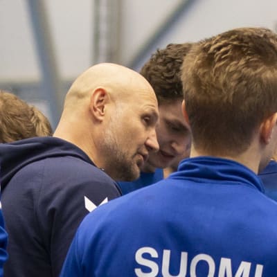 Ola Lindgren instruerar finländska spelare omkring honom.