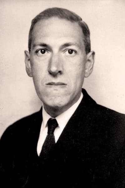 Ett svartvitt foto av en man med avlångt ansikte, överrock och slips som tittar in i kameran