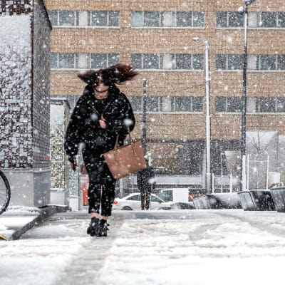 Kvinna som går i snöfall.