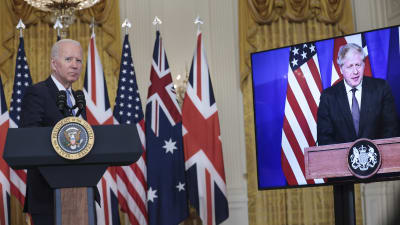 Joe Biden vid ett podium i Vita huset med Boris Johnson på en tv-skärm bredvid honom.