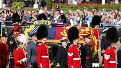 Livtroppen vid Kungliga Ridande Artilleriet går bredvid drottning Elizabeth kista i en procession.