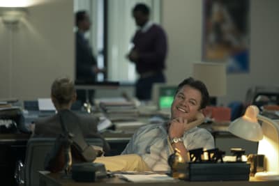 Matt Damons rollkaraktär sitter vid ett skrivbord med fötterna på bordet och talar i telefonen.