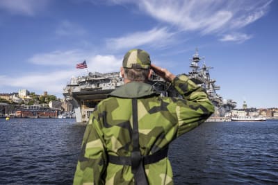 En soldat i givakt framför ett amerikanskt stridsfartyg.