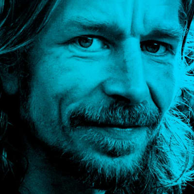 Karl Ove Knausgård katsoo kameraan siniseksi värjätyssä kuvassa.