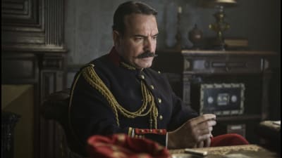 Georges Picquart sitter vid sitt skrivbord, iklädd uniform, och ser bekymrad ut. 