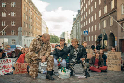 Ett gäng klimataktivister utför en protestmarsch sittande på en stadsgata.