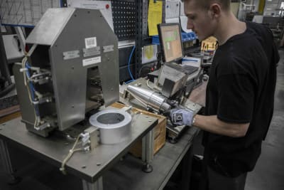 En anställd vid en ammunitionsfabrik i Frankrike framställer en artillerigranat
