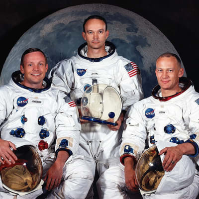 Apollo 11:n kolme astronauttia ryhmäkuvassa kuunkuvan edessä.