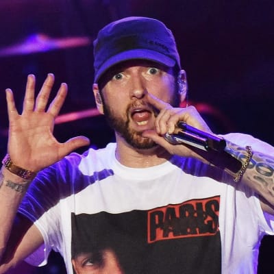 Eminem rappar i en mikrofon som han håller i handen.