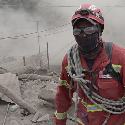 En räddningsarbetare letar efter överlevande i El Rodeo, intill vulkanen Fuego.