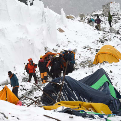 Räddningsarbetare bär de som skadats i lavinerna som utlöstes efter jordbävningen i Nepal.