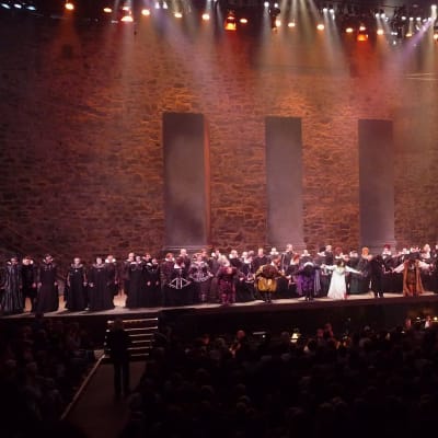 Kaikki oopperan esiintyjät lavalla vastaanottamassa suosionosoituksia Savonlinnan Oopperajuhlilla.