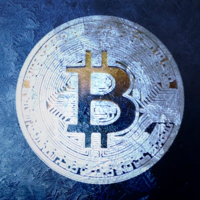 Kuvassa on tummalla taustalla jäätynyt huurteinen bitcoin - kolikko