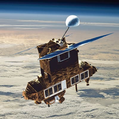 Satelliitti aurinkopaneelisiipineen ja pallomaisine mittalaitteineen maapallon pilvisen pinnan yllä.