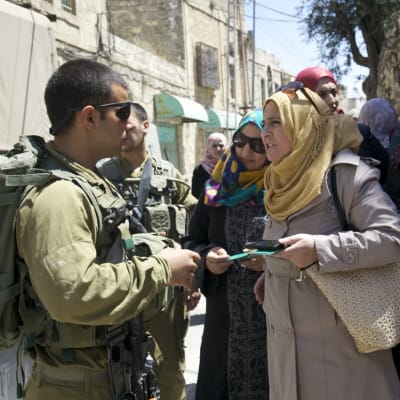 Lärare protesterar mot att israeliska soldater vägrar släppa dem förbi vägspärren