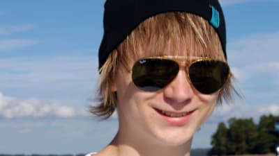 En tonårskille med solglasögon är ute på sjön