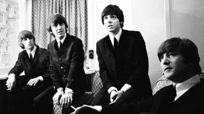 En pressbild på The Beatles klädda i kostymer.