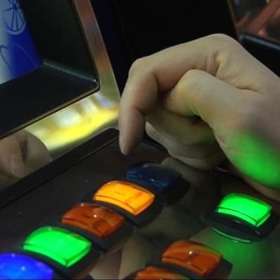 Person vid spelautomat, närbild