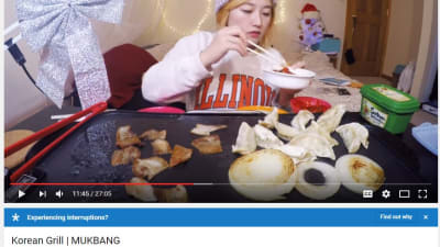 En person som äter och talar till kameran, en ny trend som kallas för Mukbang.