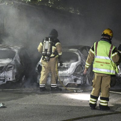 Palomiehiä sammutettujen autojen vieressä Malmössä maanantaina 15. elokuuta.