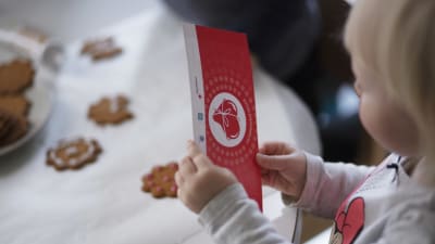 ett barn håller i ett gåvokort