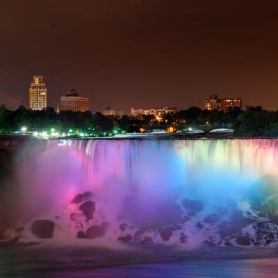 Niagarafallen fotograferade nattetid, upplysta i regnbågens alla färger. 