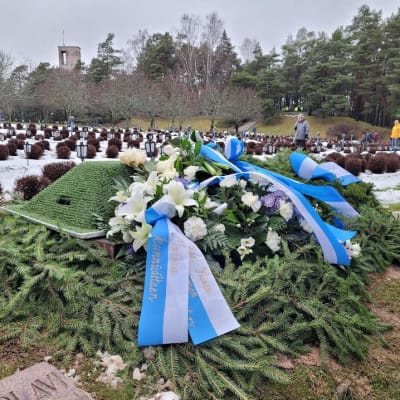 En begravningskrans ligger på begravningsplatsen, vid fänrik Gösta Karlssons grav. Bilden tagen 12.1.2023. 
