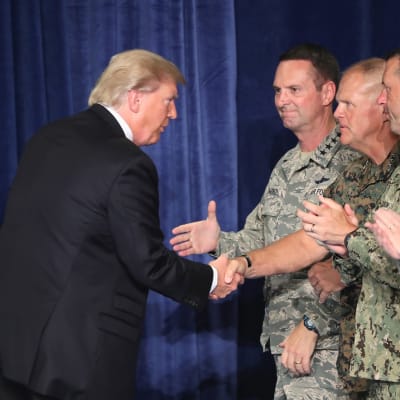 Trump kättelee rivissä seisovia sotilasjohtajia.