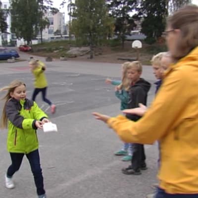 Johanna Pipping-Arrakoski hjälper Hanna Indrenius-Zalewski som deltar på en modersmålslektions utomhus.