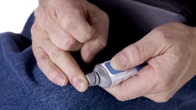 Person mäter blodsockret från fingertoppen