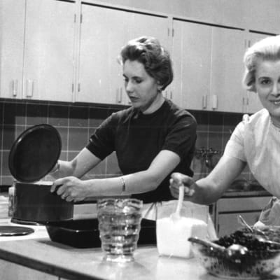 Tv-ohjelma "Keittiön puolella". Ohjaus Tytti Karttunen, suunnittelu Seija Laakso. Seija Laakso valmistaa pakasteita marjoista. Tumma nainen ja Seija Laakso työskentelevät keittiössä. (1959)