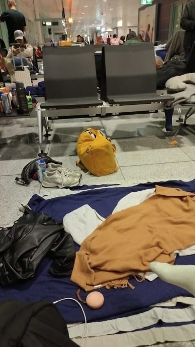 Filtar, väskor och andra saker på golvet på flygplatsen i München.