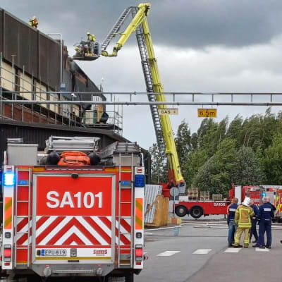 Paloautoja tehdasrakennuksen edessä.
