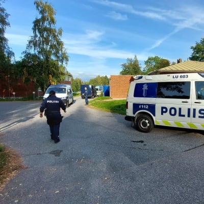 Poliisipartio on taloyhtiön pihassa.
