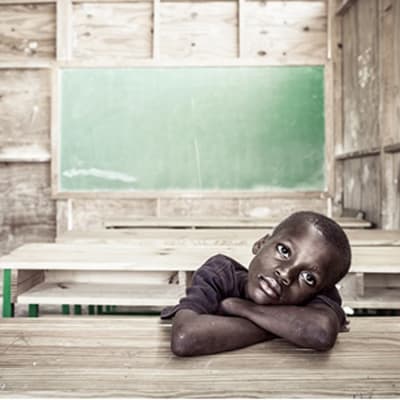 mörkhyad pojke i klassrum